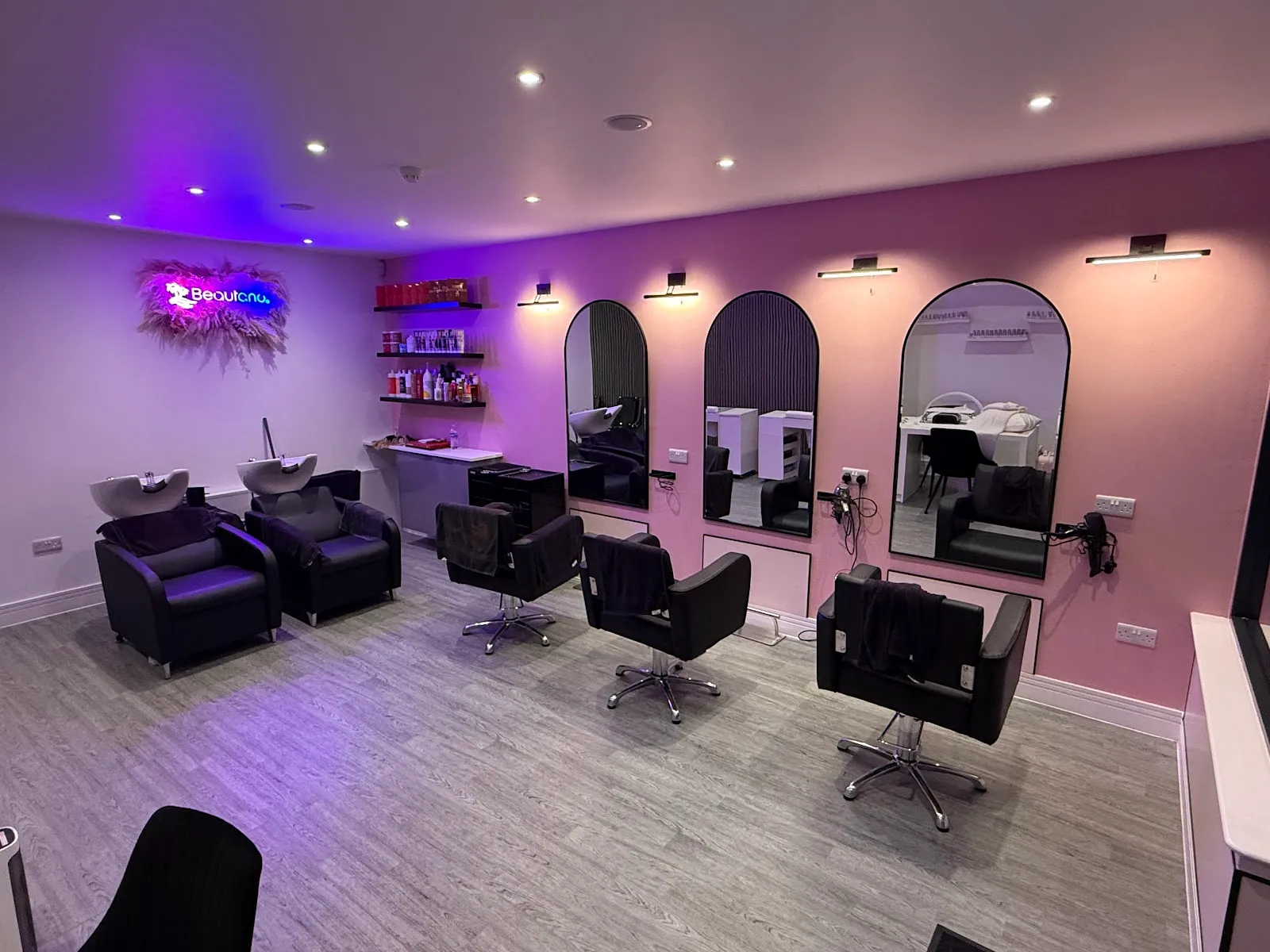 Beautano beauty suite — arch mirrors, styling chairs and the neon Beautano logo