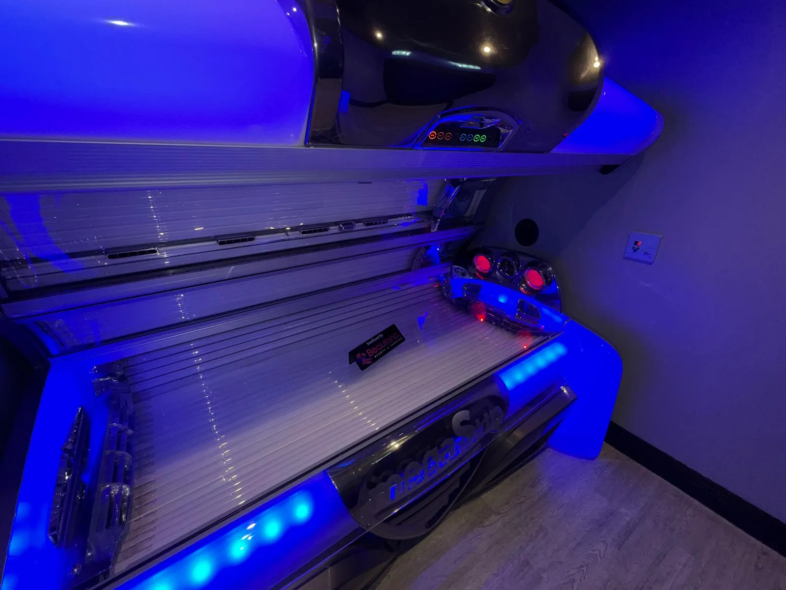 A high-pressure sunbed open and glowing blue at Beautano